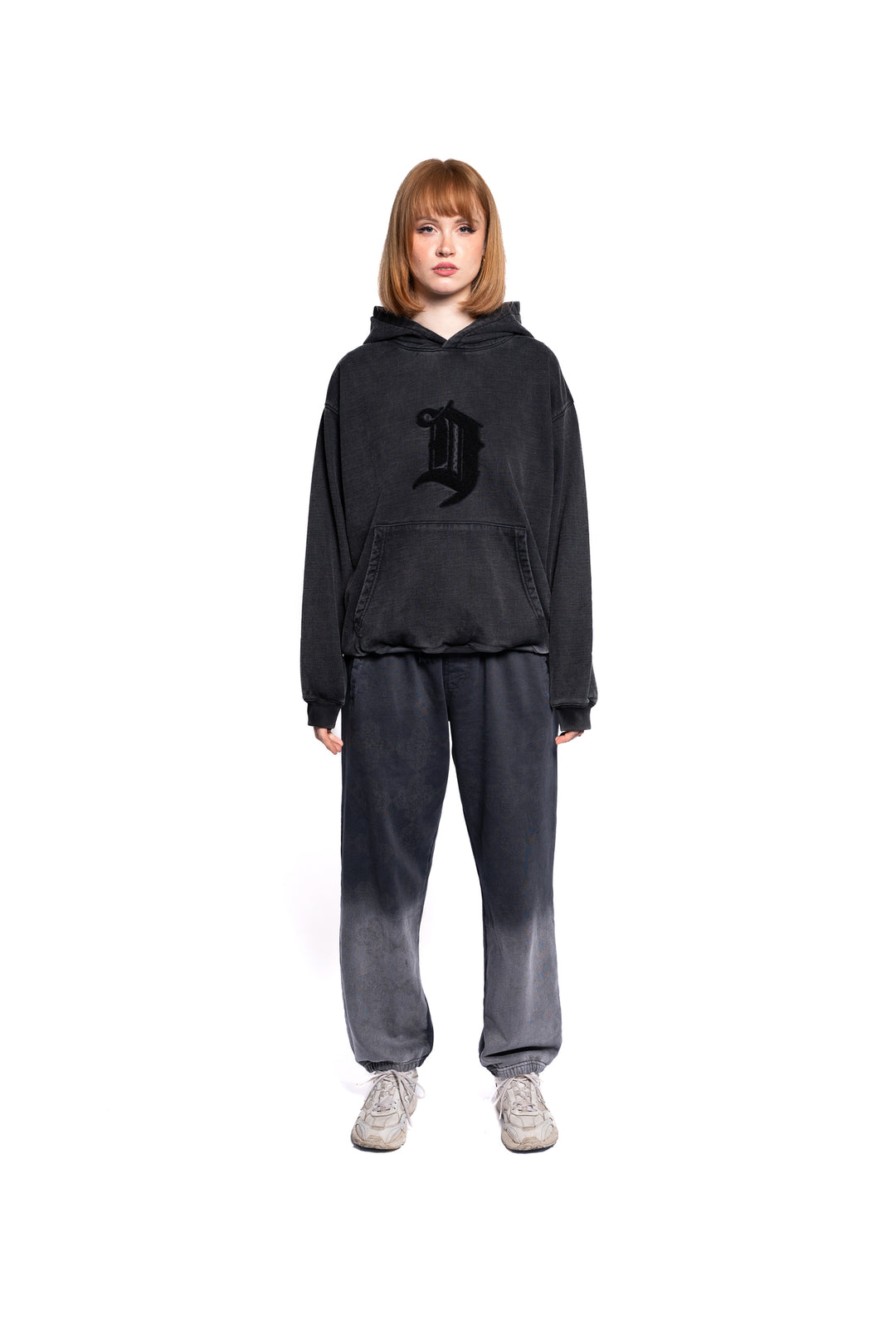 Junge Frau präsentiert den oversized black D Lab Hoodie, kombiniert mit passender Jogginghose