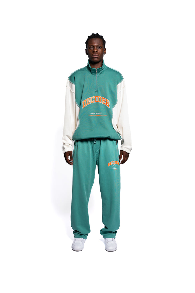 Modischer Decider Streetwear-Anzug in Pastellgrün mit Herren-Hoodie und passender Jogginghose für Männer, ergänzt durch dynamische orangene Logo-Details, ideal für einen urbanen Lifestyle.
