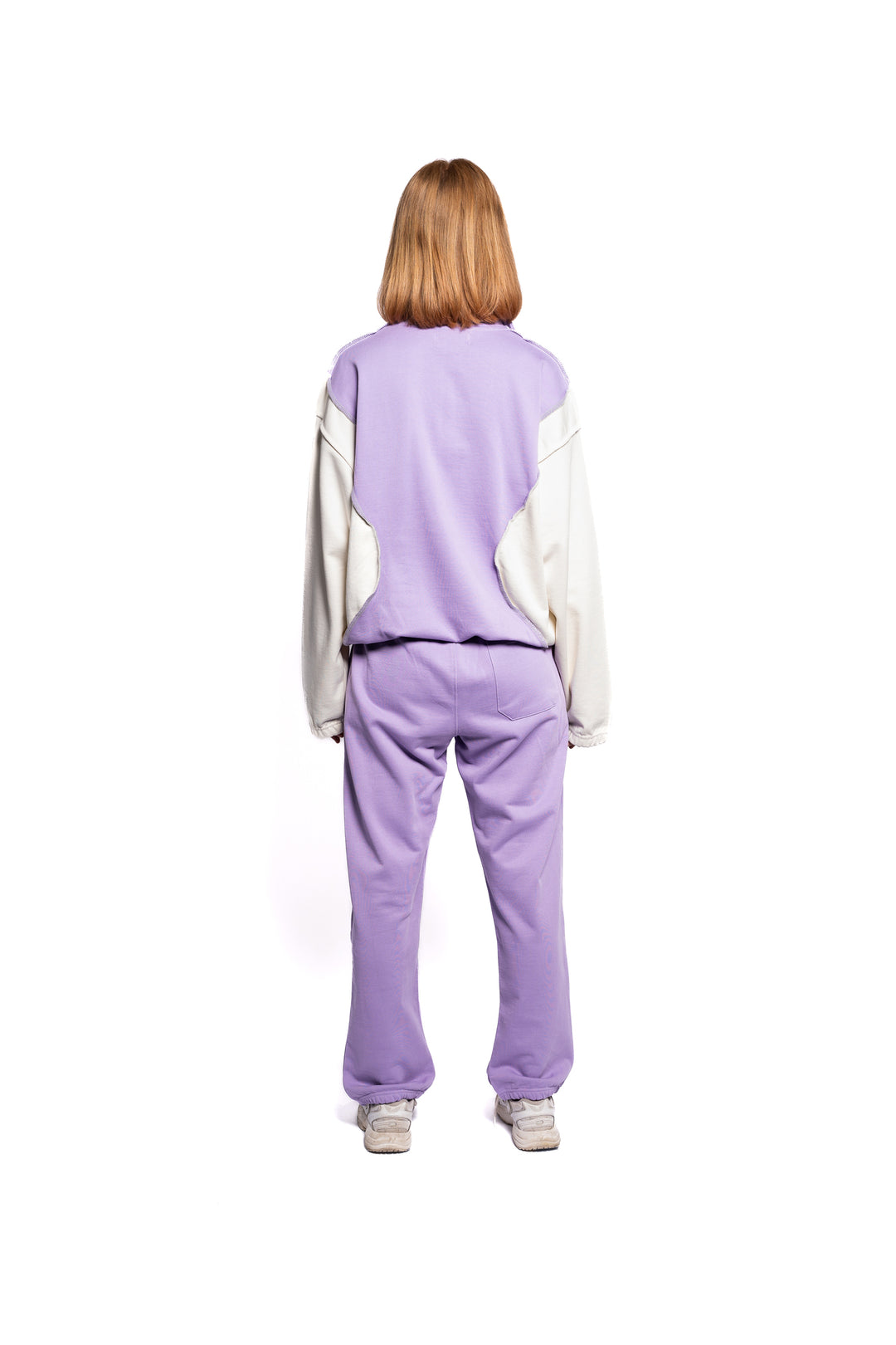 Rückansicht des Decider Jogger-Sets für Frauen, bestehend aus Hoodie und Sweatpants in Lila mit dezenter Logo-Platzierung, präsentiert von einem weiblichen Model.