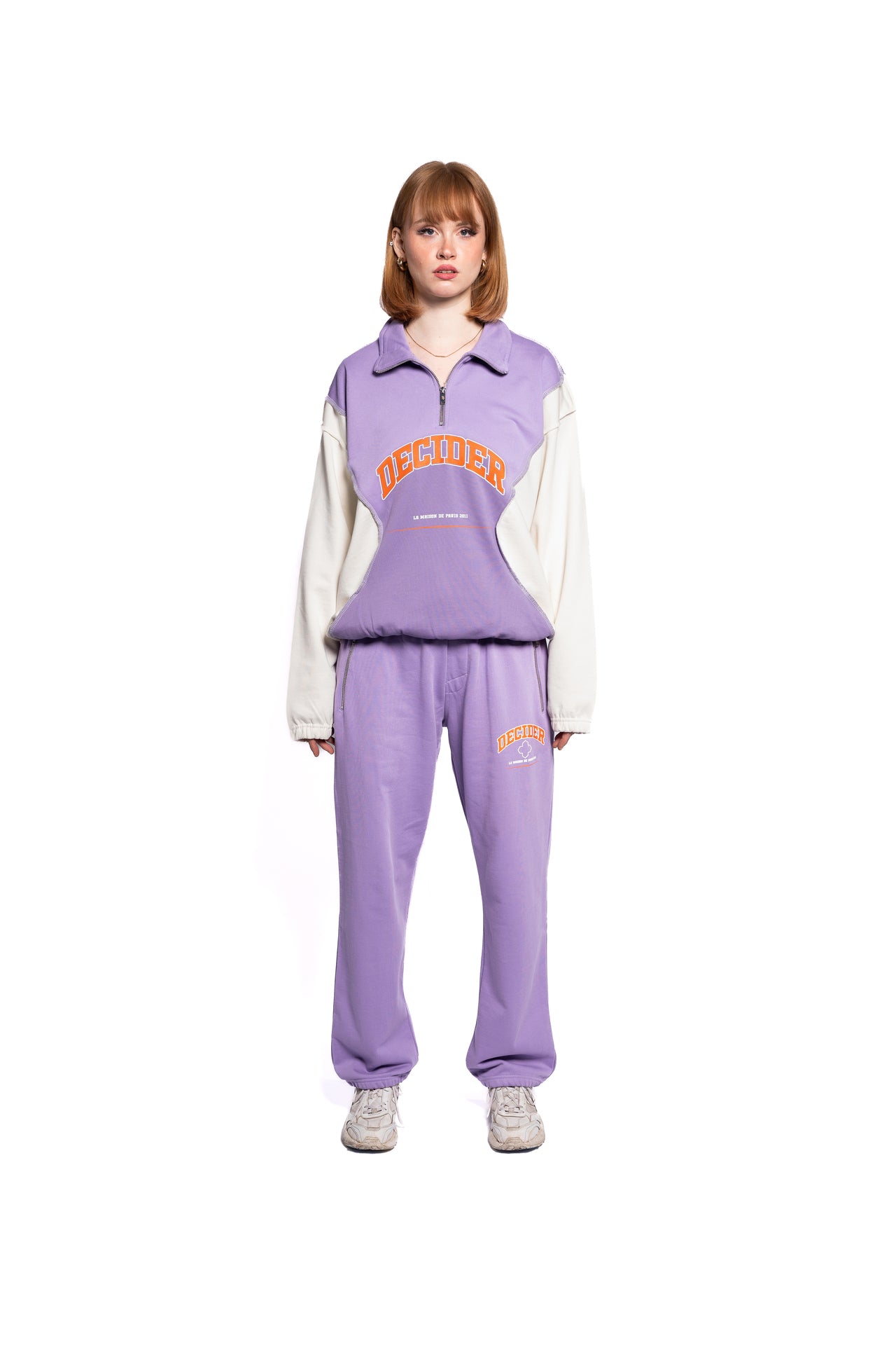 Frontansicht des Decider Streetwear-Looks mit einer Frau in pastell-lila Sweatpants und Pullover, vereint Komfort und Style für den Alltag.