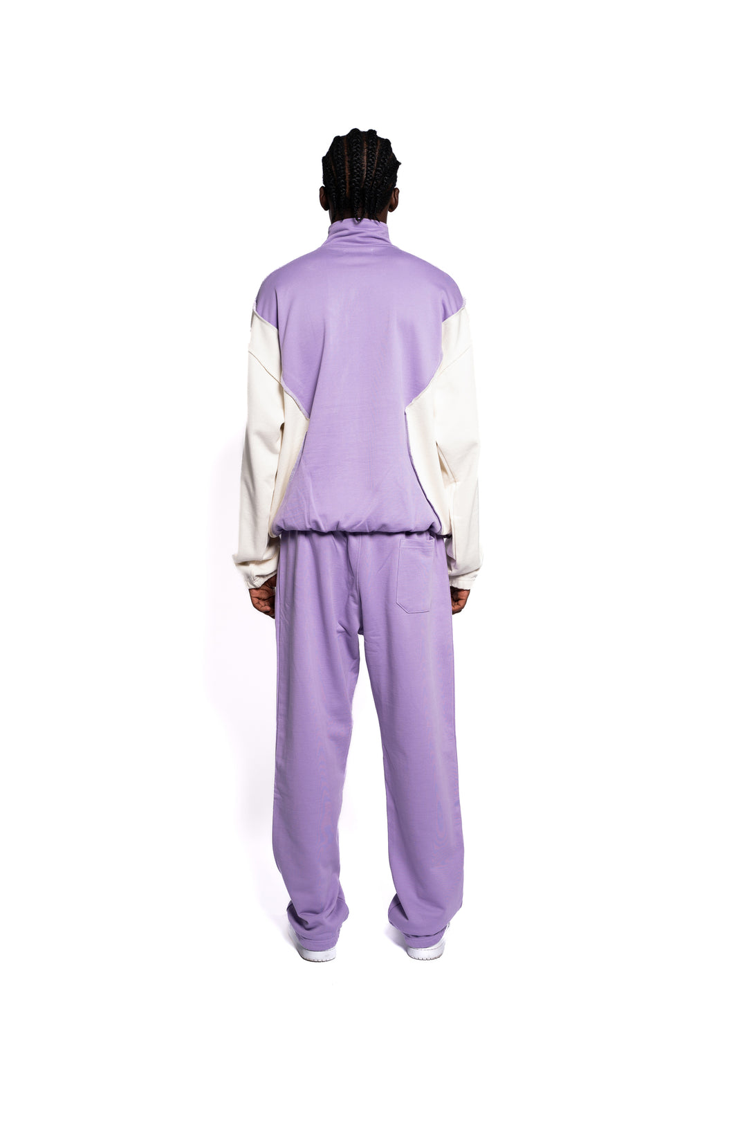 Rückansicht des Decider Streetwear-Ensembles, Hoodie und Sweatpants in Pastel Lila, subtile Logo-Highlights, getragen von einem männlichen Model, für einen coolen und lässigen Look.